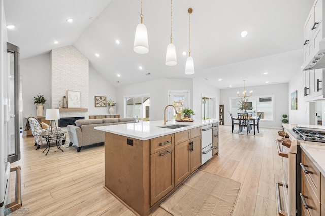 4295 Bristlecone Loop S, Fargo, ND 58104 - kitchen with a sink, white appliances, brown cabinetry, light wood-style floors, and vaulted ceiling