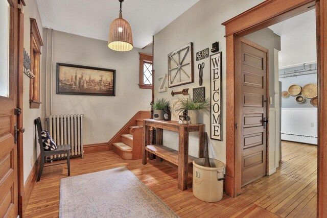 1807 Minnehaha Ave W, Saint Paul, MN 55104 - entrance foyer featuring radiator heating unit, a baseboard radiator, light wood-style flooring, and baseboards