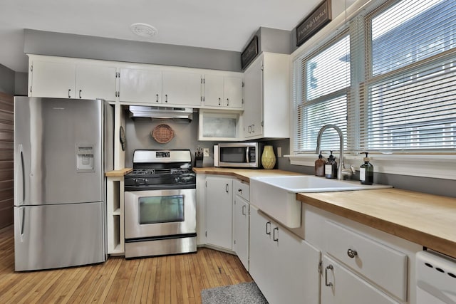 1807 Minnehaha Ave W, Saint Paul, MN 55104 - kitchen with appliances with stainless steel finishes, wooden counters, under cabinet range hood, a sink, and healthy amount of natural light