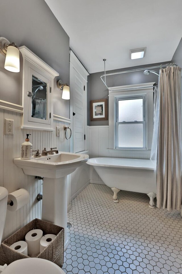 1807 Minnehaha Ave W, Saint Paul, MN 55104 - bathroom with a wainscoted wall, tile patterned floors, shower / tub combo with curtain, and toilet