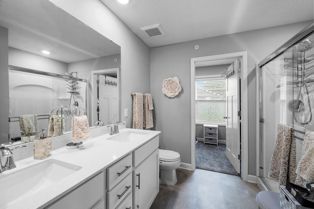 7243 Ada Dr, Lino Lakes, MN 55038 - full bathroom with toilet, a stall shower, double vanity, baseboards, and recessed lighting