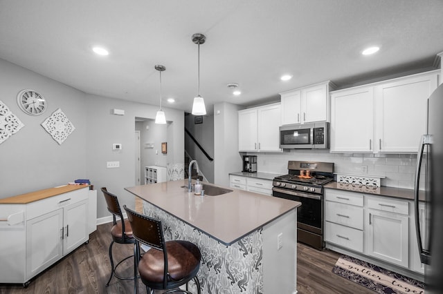 7243 Ada Dr, Lino Lakes, MN 55038 - kitchen with a sink, appliances with stainless steel finishes, dark wood finished floors, white cabinetry, and recessed lighting