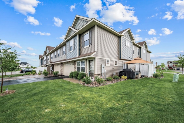 7243 Ada Dr, Lino Lakes, MN 55038 - view of side of home featuring a garage, driveway, and a lawn