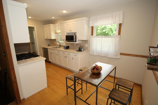 3249 Zane Ave N, Crystal, MN 55422 - kitchen with a sink, stainless steel appliances, white cabinetry, light wood-type flooring, and recessed lighting