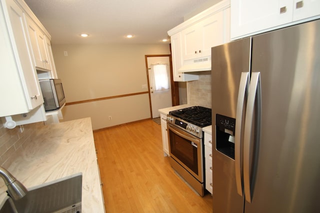 3249 Zane Ave N, Crystal, MN 55422 - kitchen featuring stainless steel appliances, exhaust hood, white cabinetry, backsplash, and recessed lighting