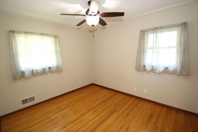 3249 Zane Ave N, Crystal, MN 55422 - unfurnished room with plenty of natural light, a ceiling fan, light wood-style floors, and baseboards