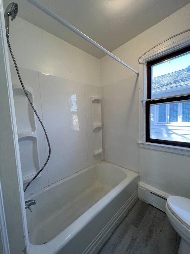 2619 2nd Ave W, Hibbing, MN 55746 - full bath with a baseboard heating unit, wood finished floors, toilet, and tub / shower combination