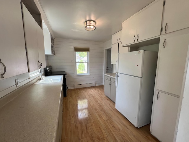 2619 2nd Ave W, Hibbing, MN 55746 - kitchen with freestanding refrigerator, baseboard heating, stainless steel electric range, light wood finished floors, and white cabinets