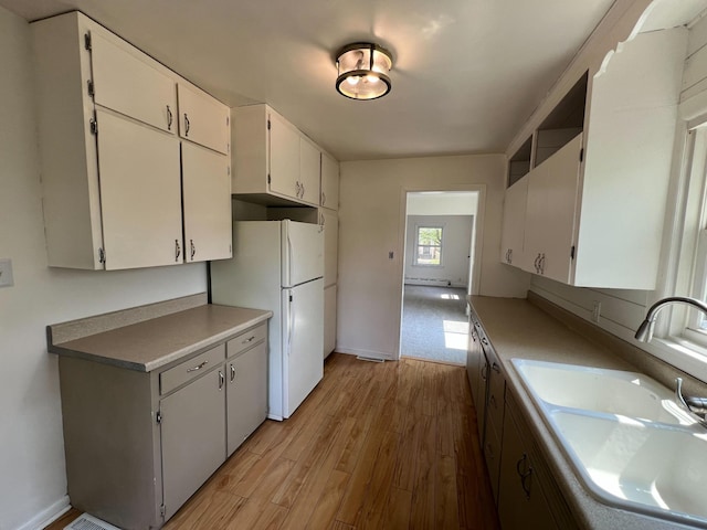 2619 2nd Ave W, Hibbing, MN 55746 - kitchen featuring freestanding refrigerator, light wood-style floors, white cabinets, and light countertops