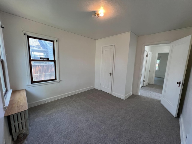 2619 2nd Ave W, Hibbing, MN 55746 - unfurnished bedroom featuring dark colored carpet and multiple windows
