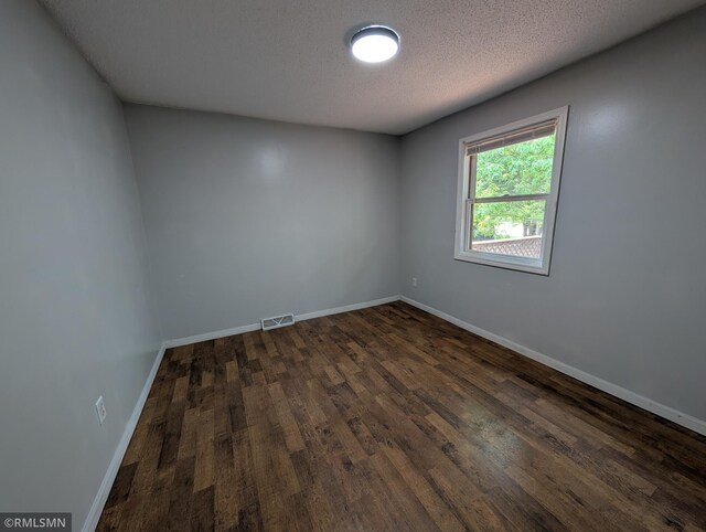 353 44th Ave NW, Powers Twp, MN 56435 - spare room featuring dark wood finished floors, baseboards, and a textured ceiling