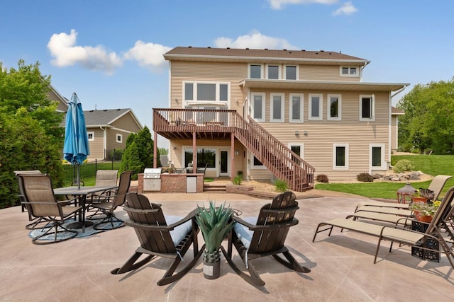 1900 Legacy Dr, Faribault, MN 55021 - back of property with an outdoor kitchen, an outdoor fire pit, a deck, a patio area, and stairs