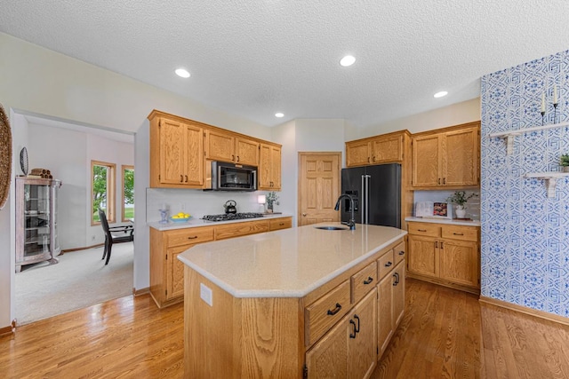 1900 Legacy Dr, Faribault, MN 55021 - kitchen with black appliances, a sink, light countertops, light wood-style floors, and a textured ceiling