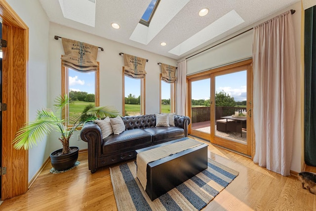 1900 Legacy Dr, Faribault, MN 55021 - living room featuring a skylight, light wood finished floors, a textured ceiling, and recessed lighting