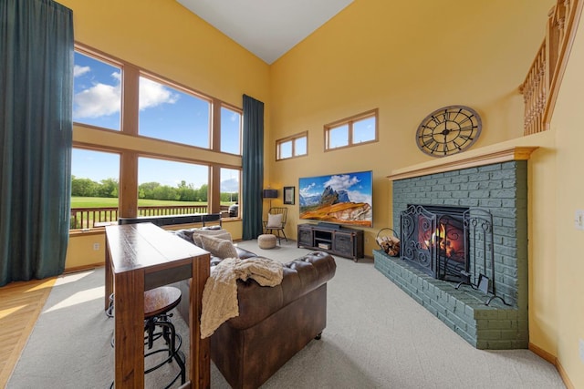 1900 Legacy Dr, Faribault, MN 55021 - carpeted living room featuring a towering ceiling, healthy amount of natural light, a brick fireplace, and baseboards