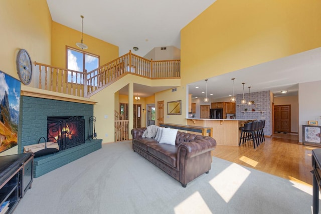 1900 Legacy Dr, Faribault, MN 55021 - living area with light carpet, a brick fireplace, a towering ceiling, and light wood-type flooring
