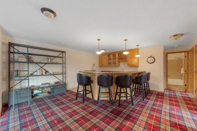 1900 Legacy Dr, Faribault, MN 55021 - kitchen with a textured ceiling, a peninsula, carpet floors, baseboards, and a breakfast bar