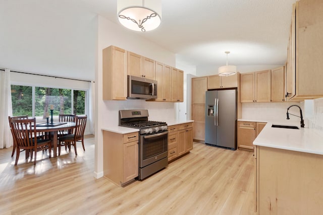 18799 147th St NW, Elk River, MN 55330 - kitchen with appliances with stainless steel finishes, light brown cabinetry, a sink, light wood finished floors, and light countertops