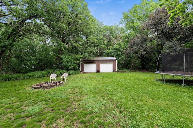 18799 147th St NW, Elk River, MN 55330 - view of grassy yard with a trampoline, a detached garage, an outbuilding, and an outdoor fire pit