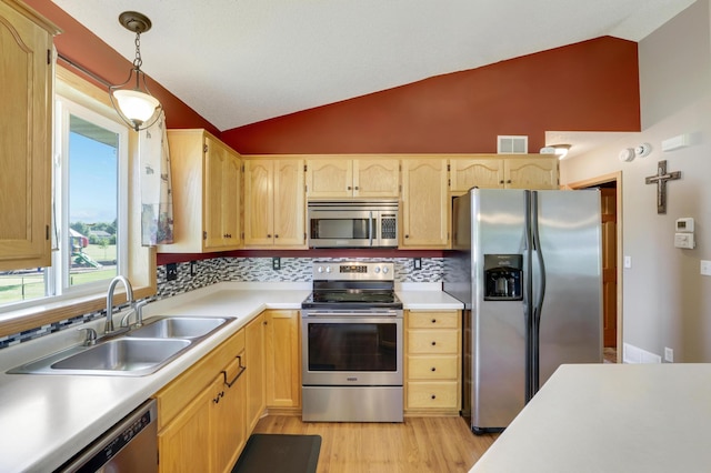 12966 Carole Dr, Becker, MN 55308 - kitchen featuring appliances with stainless steel finishes, lofted ceiling, backsplash, light wood-style flooring, and light countertops