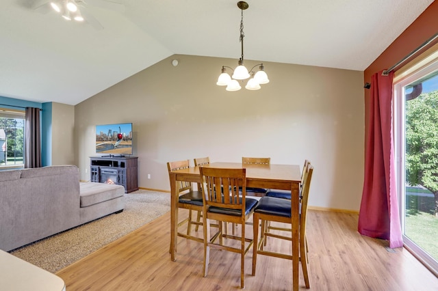 12966 Carole Dr, Becker, MN 55308 - dining area with light wood-style flooring, a glass covered fireplace, vaulted ceiling, a chandelier, and ceiling fan