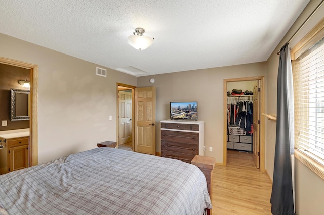 12966 Carole Dr, Becker, MN 55308 - bedroom with light wood-style floors, a spacious closet, and ensuite bathroom