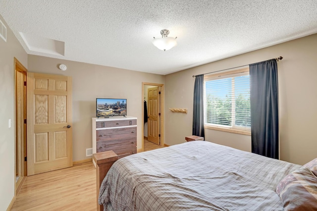 12966 Carole Dr, Becker, MN 55308 - bedroom with light wood-style floors, a textured ceiling, and a spacious closet