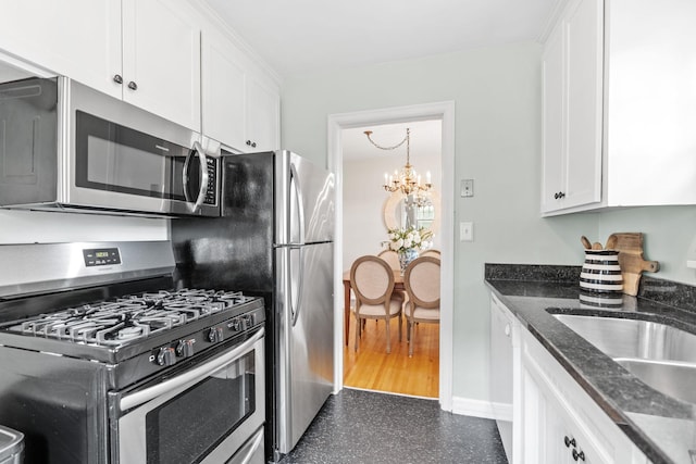 5737 Vincent Ave S, Minneapolis, MN 55410 - kitchen with stainless steel appliances, white cabinets, a chandelier, dark stone counters, and baseboards