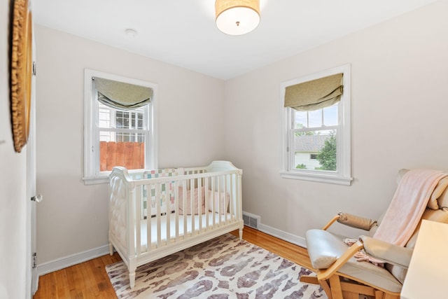 5737 Vincent Ave S, Minneapolis, MN 55410 - bedroom featuring wood finished floors, baseboards, and a crib