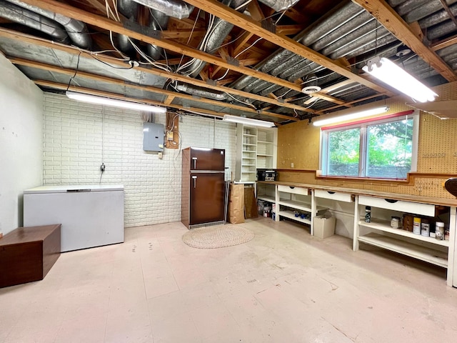 1319 3rd St, Red Wing, MN 55066 - below grade area featuring refrigerator, brick wall, a workshop area, and electric panel