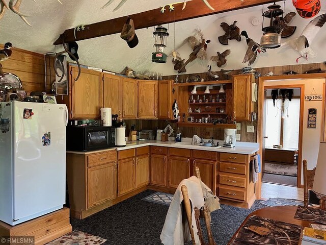 26612 State Highway 47, Aitkin, MN 56431 - kitchen featuring freestanding refrigerator, black microwave, open shelves, light countertops, and wood walls