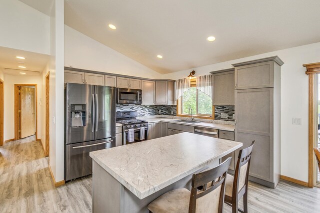 918 Mallard St NE, Hanover, MN 55341 - kitchen with stainless steel appliances, a sink, light wood-style flooring, vaulted ceiling, and tasteful backsplash