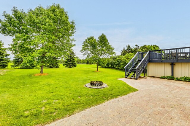 918 Mallard St NE, Hanover, MN 55341 - view of grassy yard featuring stairs, an outdoor fire pit, a wooden deck, and view of scattered trees