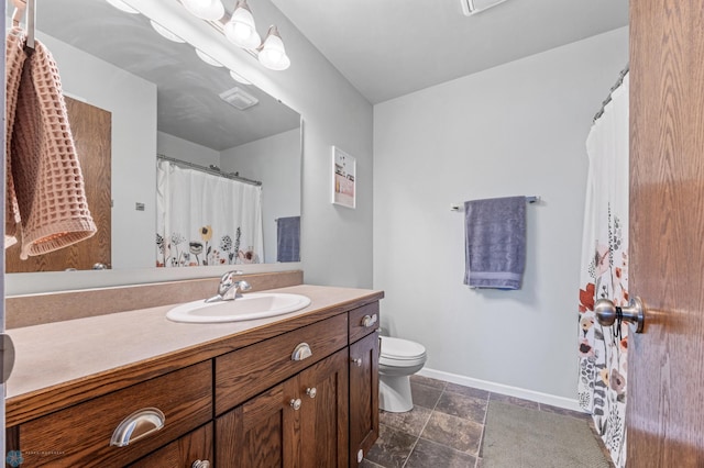 934 31st Ave W, West Fargo, ND 58078 - bathroom with vanity, toilet, stone finish floors, and baseboards