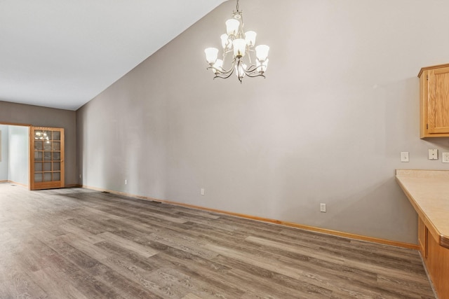 185 21st Ave SW, Cambridge, MN 55008 - unfurnished dining area featuring wood finished floors, a chandelier, lofted ceiling, and baseboards