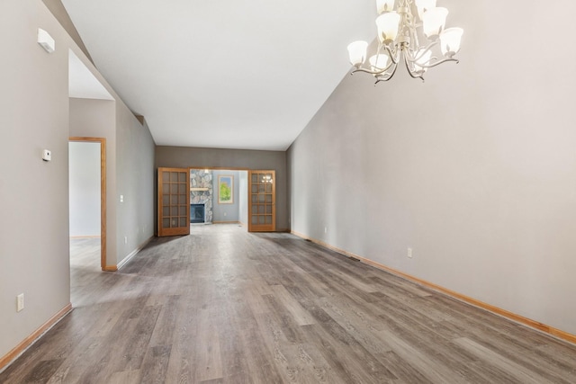185 21st Ave SW, Cambridge, MN 55008 - unfurnished living room with a chandelier, wood finished floors, and baseboards