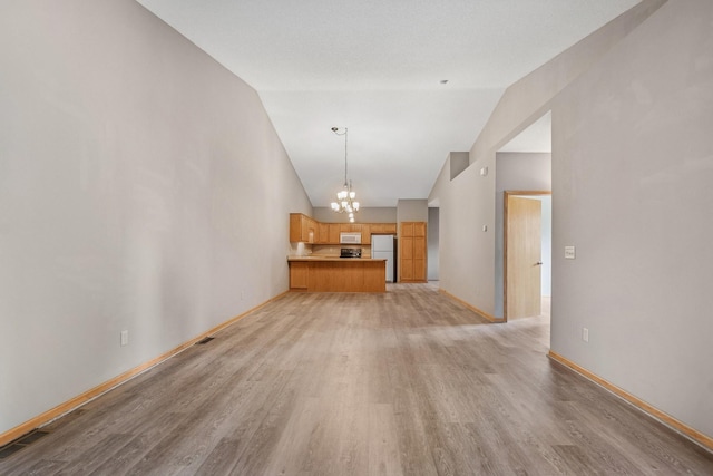 185 21st Ave SW, Cambridge, MN 55008 - unfurnished living room with a chandelier, high vaulted ceiling, light wood-type flooring, and baseboards