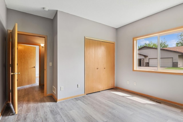 185 21st Ave SW, Cambridge, MN 55008 - unfurnished bedroom with wood finished floors, baseboards, and a closet