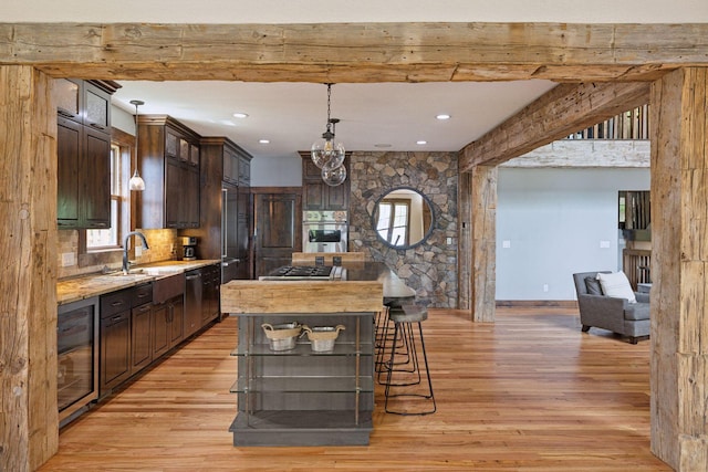 3920 Hawthorne Cir, Chanhassen, MN 55331 - kitchen with beverage cooler, appliances with stainless steel finishes, light wood-style floors, dark brown cabinets, and a sink