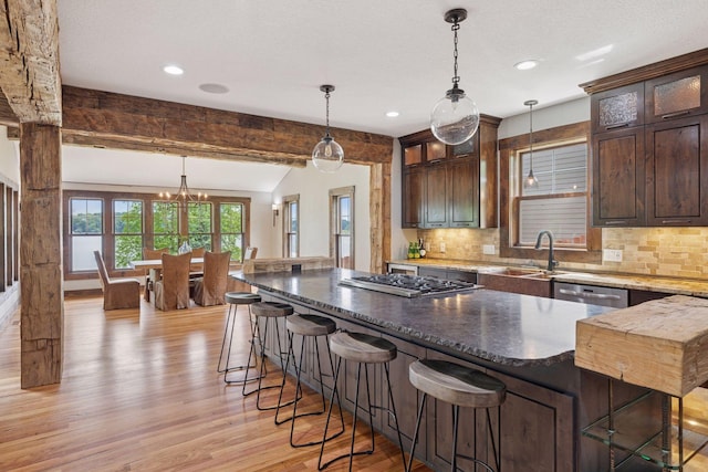 3920 Hawthorne Cir, Chanhassen, MN 55331 - kitchen featuring a sink, light wood finished floors, tasteful backsplash, dark brown cabinets, and decorative light fixtures