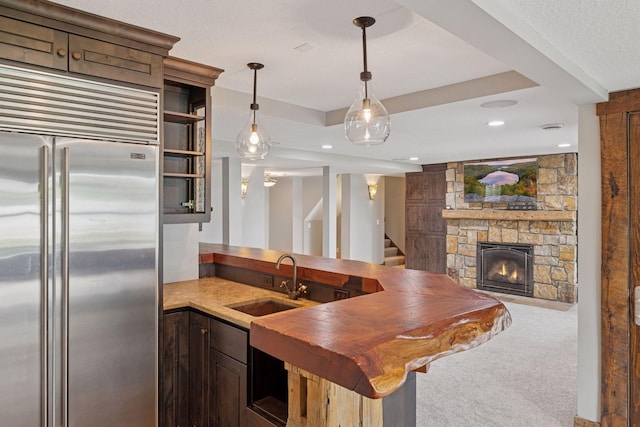 3920 Hawthorne Cir, Chanhassen, MN 55331 - kitchen with built in refrigerator, a sink, open shelves, a stone fireplace, and a peninsula