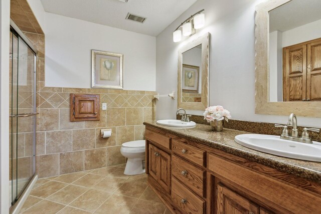 5929 Oxford St N, Shoreview, MN 55126 - bathroom featuring double vanity, a stall shower, tile patterned floors, tile walls, and a wainscoted wall