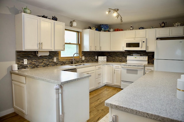6014 6th St, Lake Park, MN 56554 - kitchen with white appliances, a sink, light wood-style flooring, decorative backsplash, and white cabinets