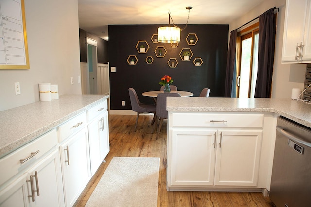 6014 6th St, Lake Park, MN 56554 - kitchen with stainless steel dishwasher, light wood finished floors, a chandelier, a peninsula, and white cabinets