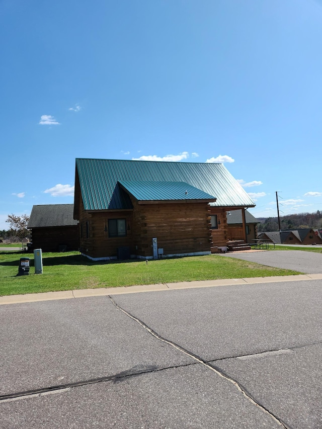 303 Hilltop Ct, Warrens, WI 54666 - view of side of home with log siding and a lawn