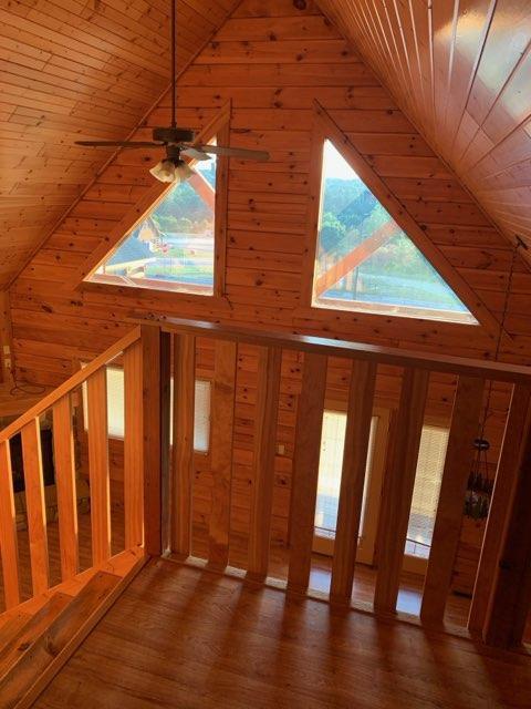303 Hilltop Ct, Warrens, WI 54666 - unfurnished living room with wooden walls, plenty of natural light, high vaulted ceiling, wood ceiling, and wood finished floors