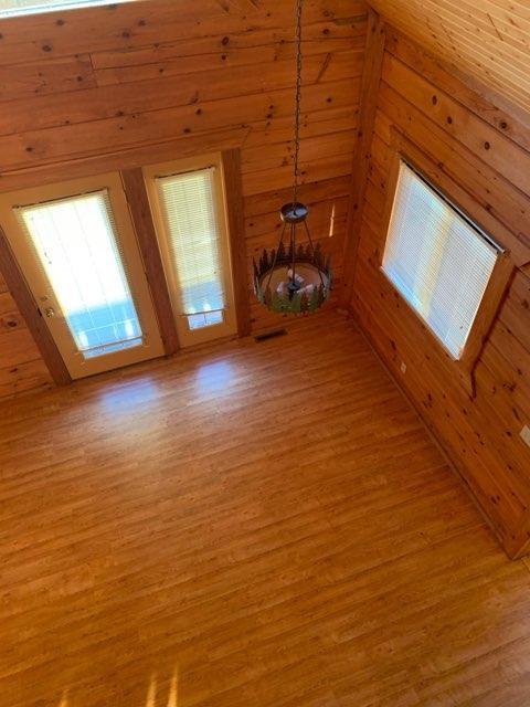 303 Hilltop Ct, Warrens, WI 54666 - unfurnished living room featuring light wood finished floors and wood walls