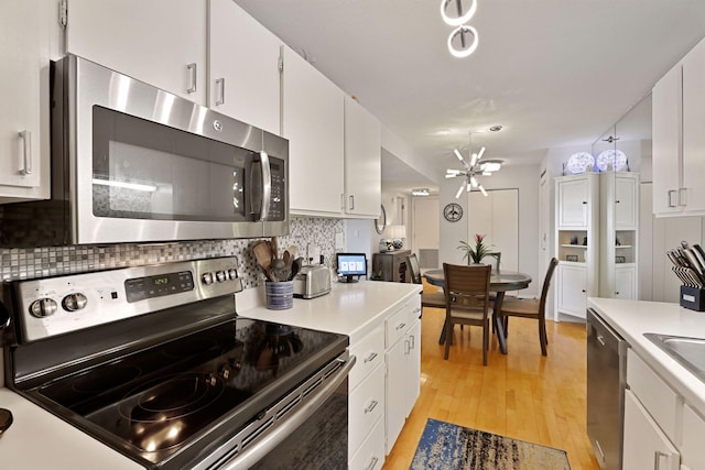 121 Washington Ave S Unit 1816, Minneapolis, MN 55401 - kitchen with appliances with stainless steel finishes, light countertops, decorative backsplash, light wood finished floors, and white cabinets