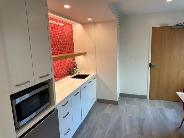 121 Washington Ave S Unit 1816, Minneapolis, MN 55401 - kitchen featuring stainless steel microwave, a sink, light countertops, modern cabinets, and white cabinetry