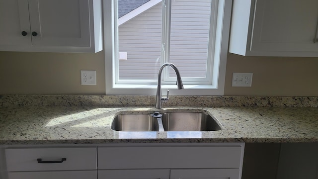 1027 45th Ave NE, Saint Cloud, MN 56304 - kitchen view of a sink, white cabinets, and light stone counters